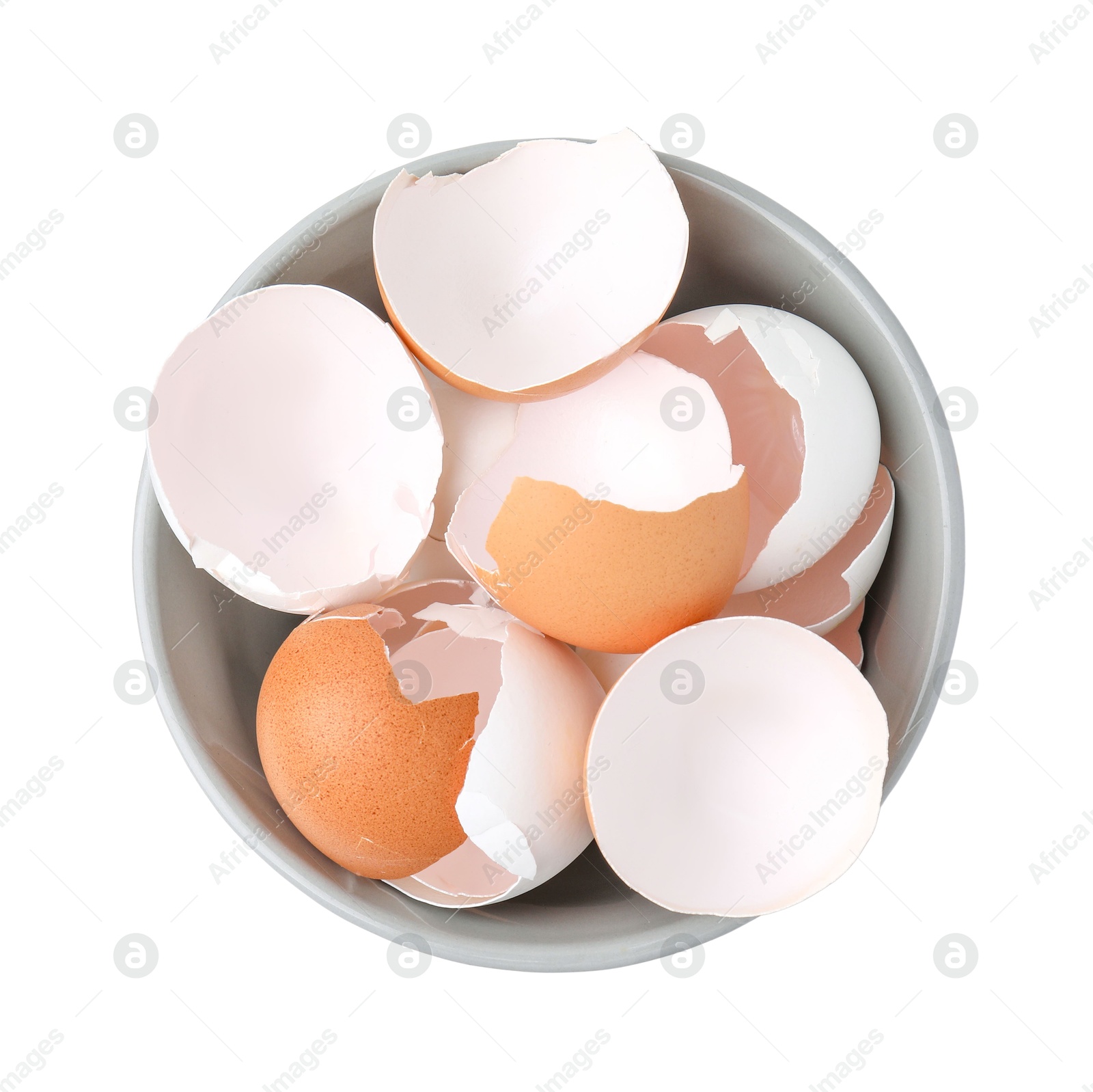 Photo of Broken eggshells in bowl isolated on white, top view