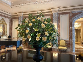 Berlin, Germany - July 3, 2024: Vase with beautiful lilies and dahlias on mirrored table in Regent Berlin Hotel