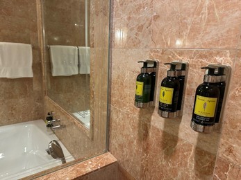 Berlin, Germany - July 2, 2024: Bottles with body care products on tiled wall in Regent Berlin Hotel bathroom