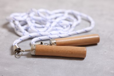 Photo of Skipping rope on grey table, closeup. Sports equipment