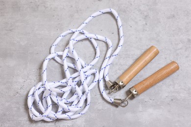 Photo of Skipping rope on grey table, top view. Sports equipment