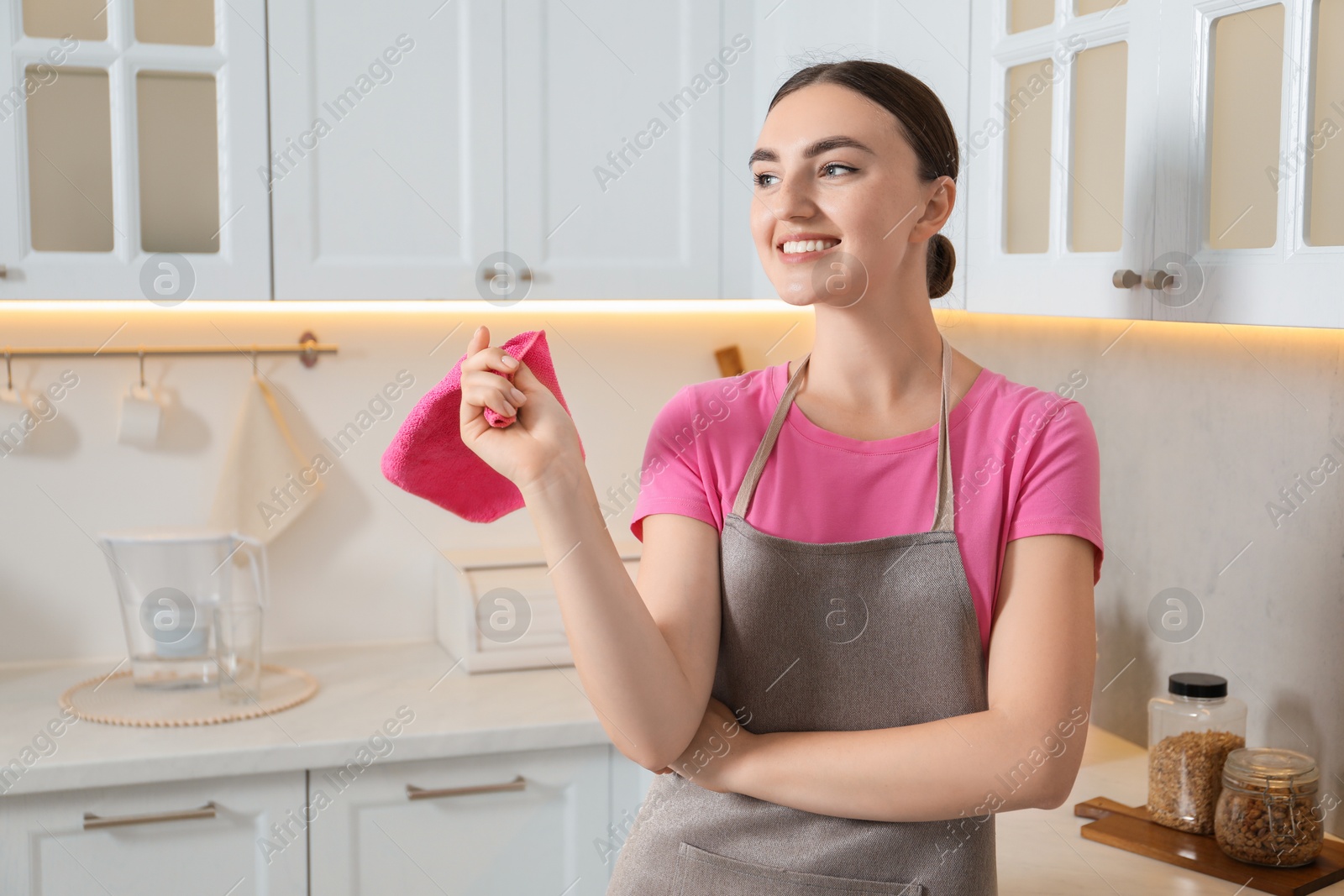 Photo of Beautiful young woman with rag in kitchen. Cleaning room