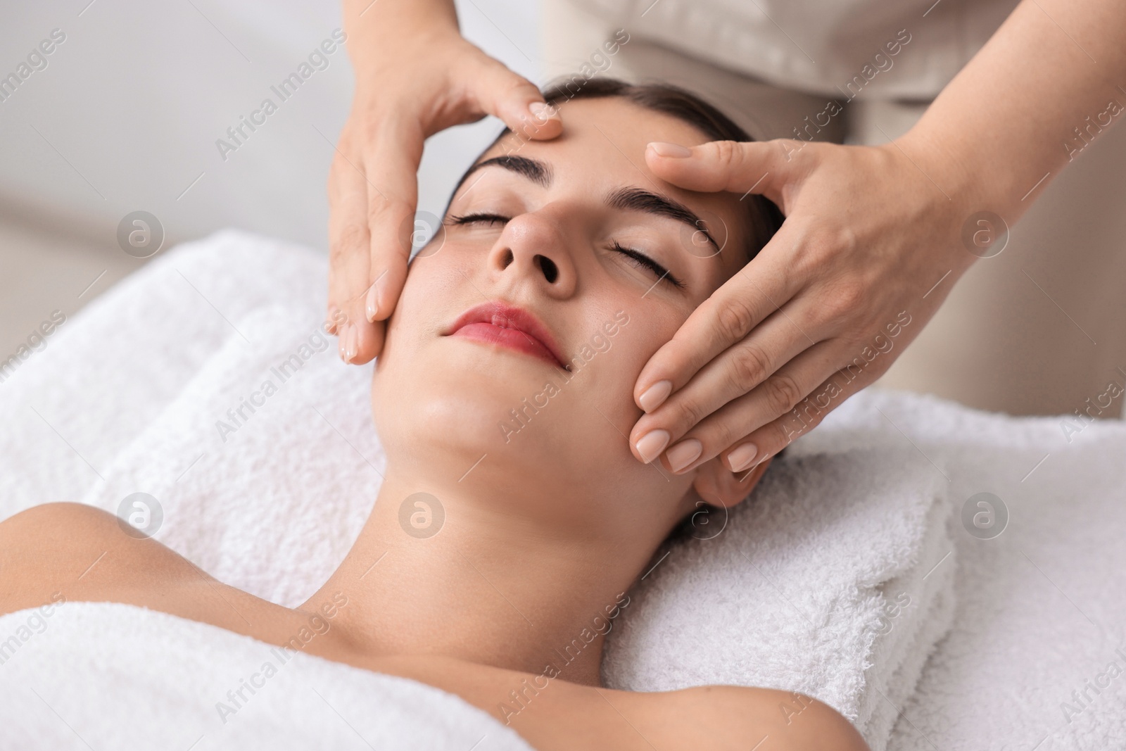 Photo of Attractive woman enjoying face massage, closeup. Beauty procedure