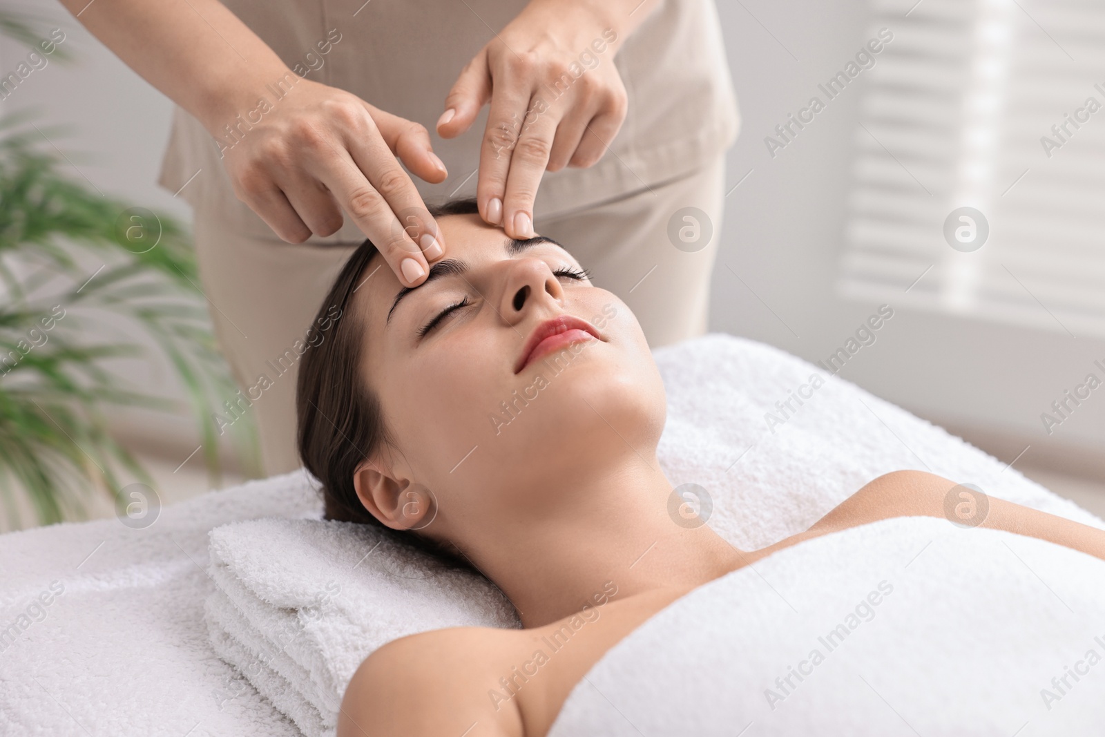 Photo of Attractive woman enjoying face massage, closeup. Beauty procedure