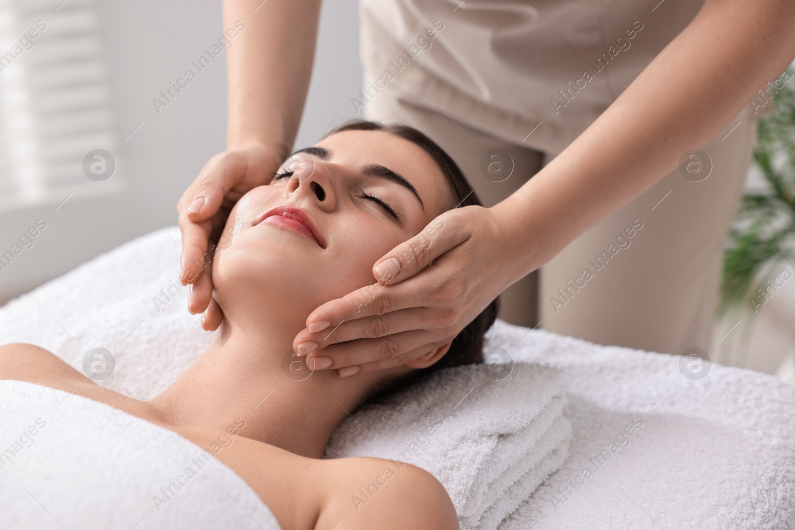 Photo of Attractive woman enjoying face massage, closeup. Beauty procedure