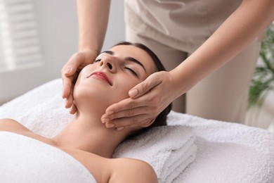 Attractive woman enjoying face massage, closeup. Beauty procedure