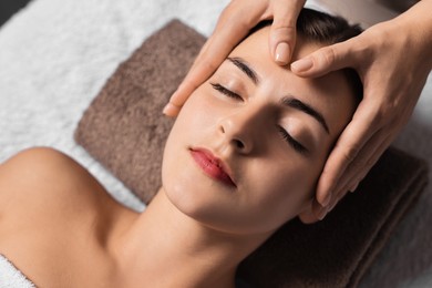 Photo of Attractive woman enjoying face massage, above view. Beauty procedure