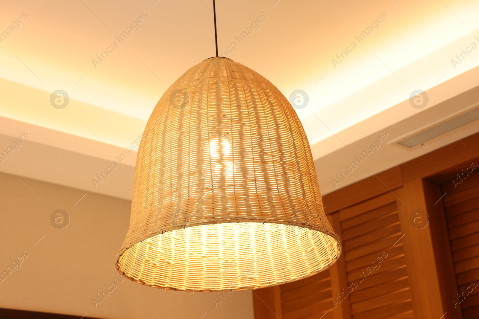 Photo of Stylish pendant lamp on ceiling indoors, low angle view