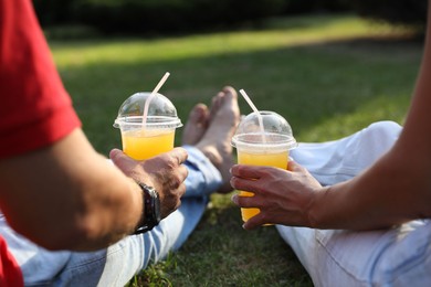 Couple spending time together on green lawn in park, closeup