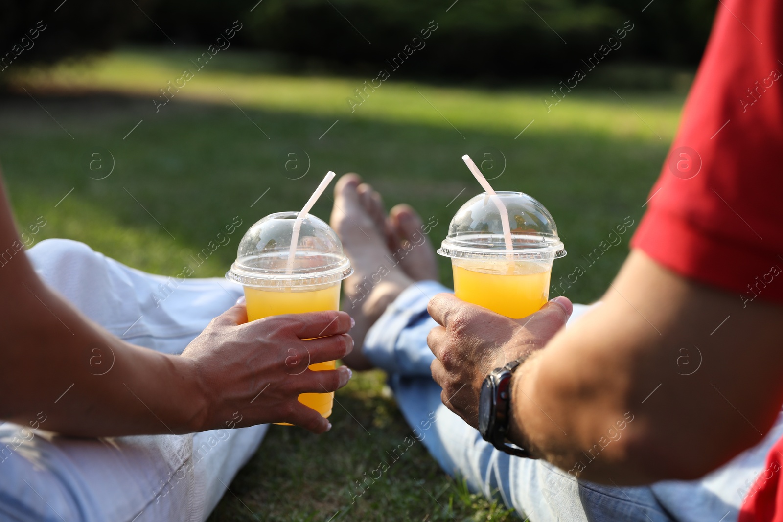 Photo of Couple spending time together on green lawn in park, closeup