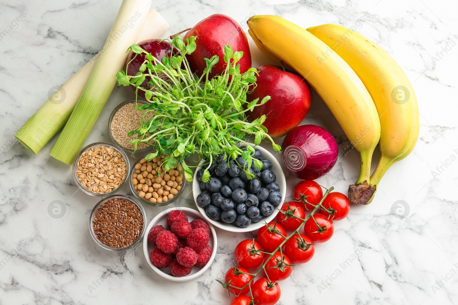 Photo of Different fresh products on white marble table, flat lay. Source of prebiotics