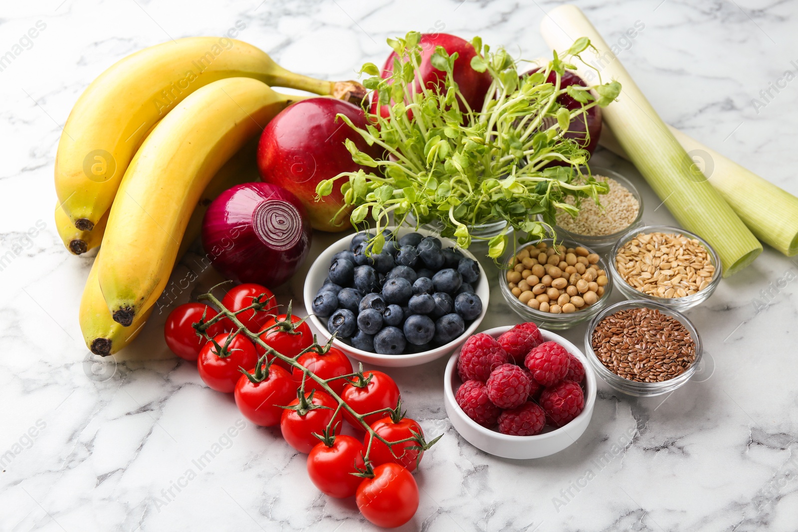 Photo of Different fresh products on white marble table. Source of prebiotics