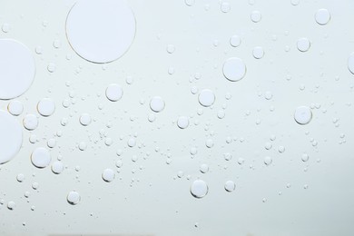 Photo of Sample of cosmetic oil on light grey background, macro view