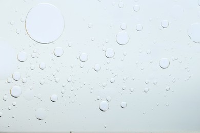 Photo of Sample of cosmetic oil on light grey background, macro view