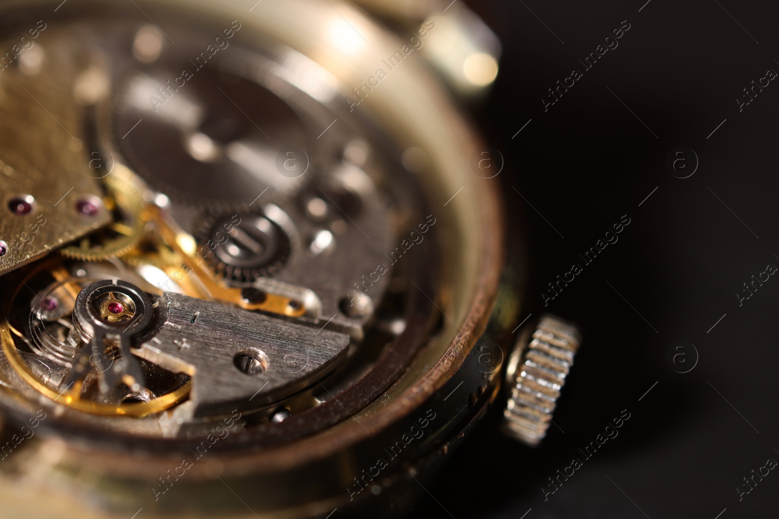 Photo of Mechanism of vintage wrist watch on black background, closeup