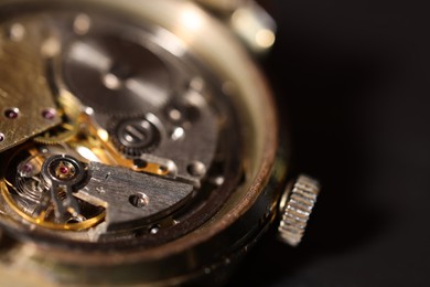 Photo of Mechanism of vintage wrist watch on black background, closeup