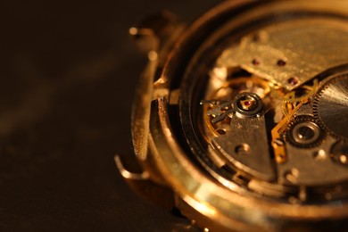 Photo of Mechanism of vintage wrist watch on black background, closeup