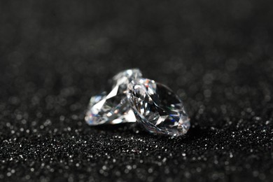 Photo of Beautiful dazzling diamonds on dark shiny background, closeup