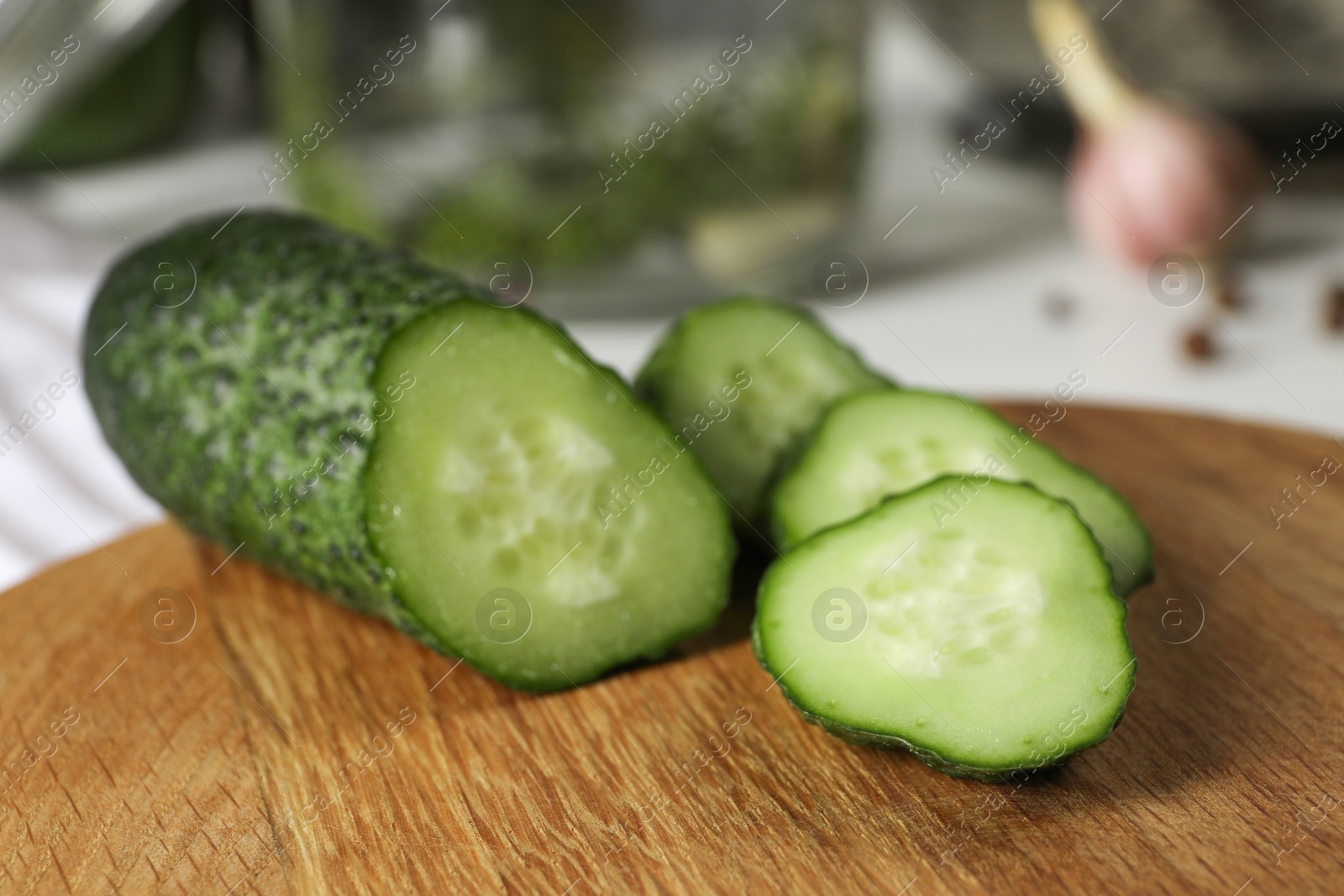 Photo of Wooden board with fresh cut cucumber on table, closeup