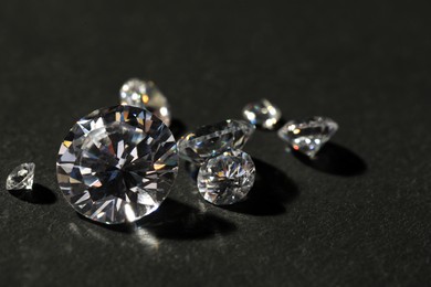 Photo of Many beautiful shiny diamonds on grey table, closeup