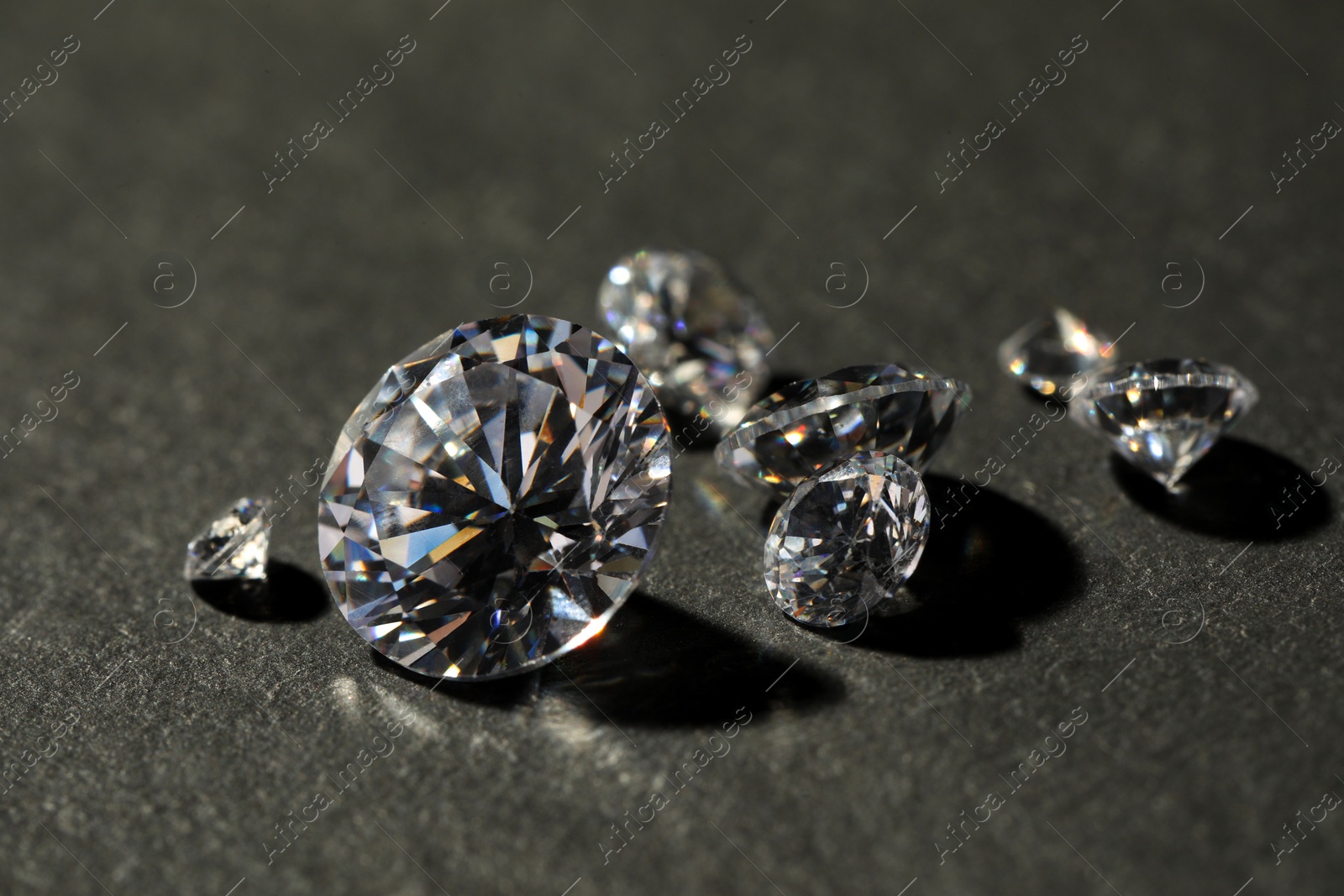 Photo of Many beautiful shiny diamonds on grey table, closeup