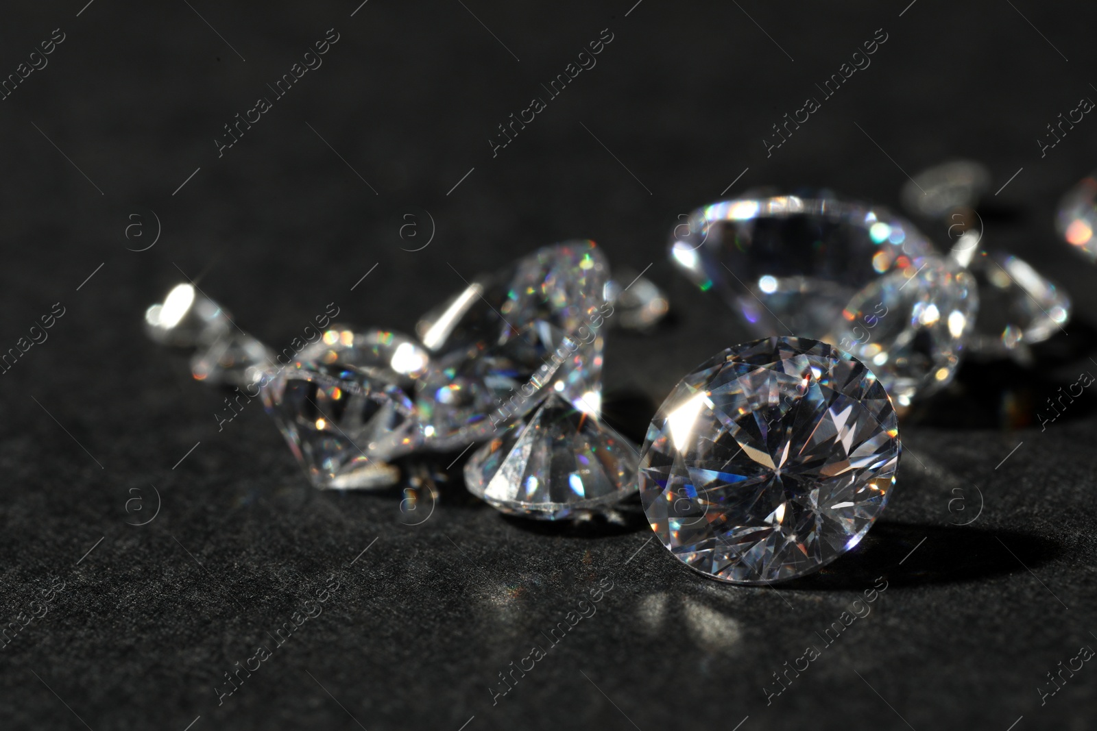 Photo of Many beautiful shiny diamonds on black table, closeup