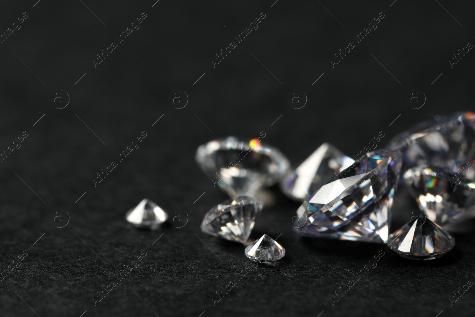 Photo of Many beautiful shiny diamonds on black table, closeup. Space for text