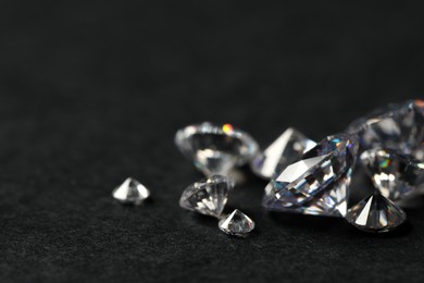 Photo of Many beautiful shiny diamonds on black table, closeup. Space for text