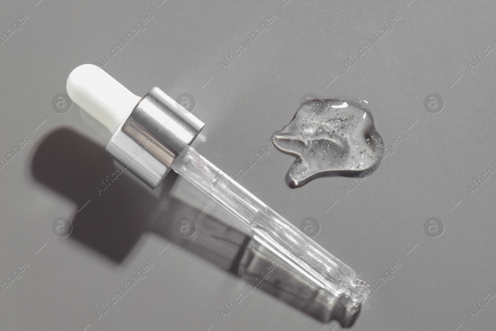 Photo of Pipette with cosmetic serum on grey background, above view