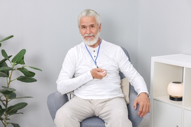 Senior man pressing emergency call button at home