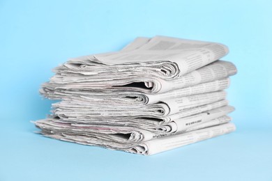 Photo of Stack of newspapers on light blue background