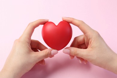 Photo of Woman holding red heart on pink background, closeup