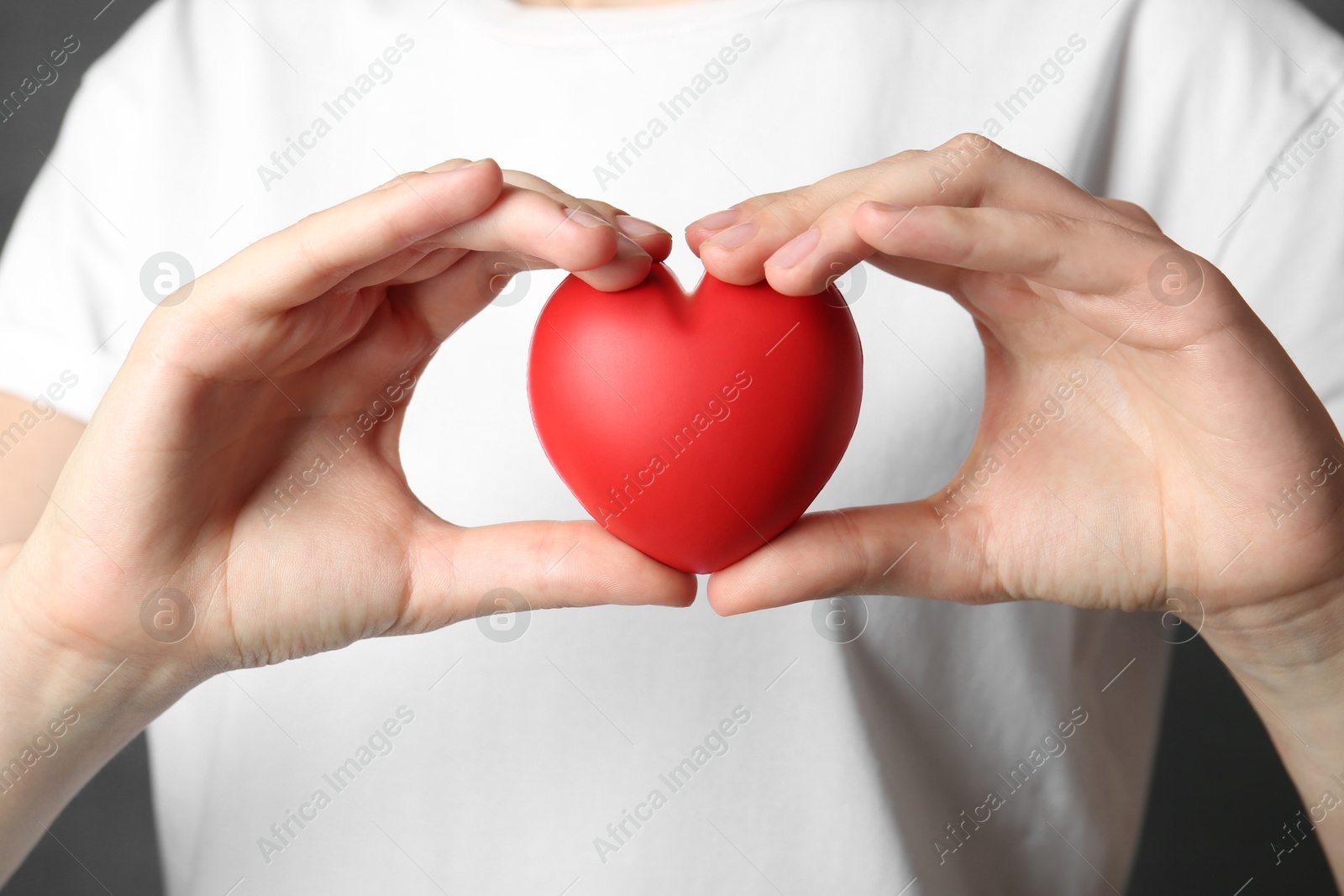 Photo of Woman holding red heart on grey background, closeup