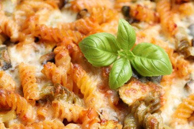 Photo of Delicious al forno pasta with basil, closeup