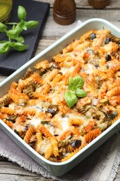 Photo of Delicious al forno pasta in baking dish on wooden table, closeup