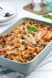 Photo of Delicious al forno pasta in baking dish on white wooden table, closeup