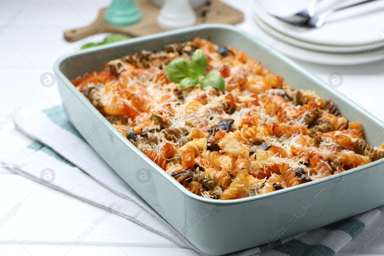 Photo of Delicious al forno pasta in baking dish on white wooden table, closeup