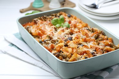 Photo of Delicious al forno pasta in baking dish on white wooden table, closeup