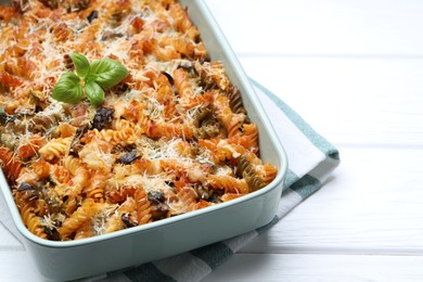 Photo of Delicious al forno pasta in baking dish on white wooden table, closeup