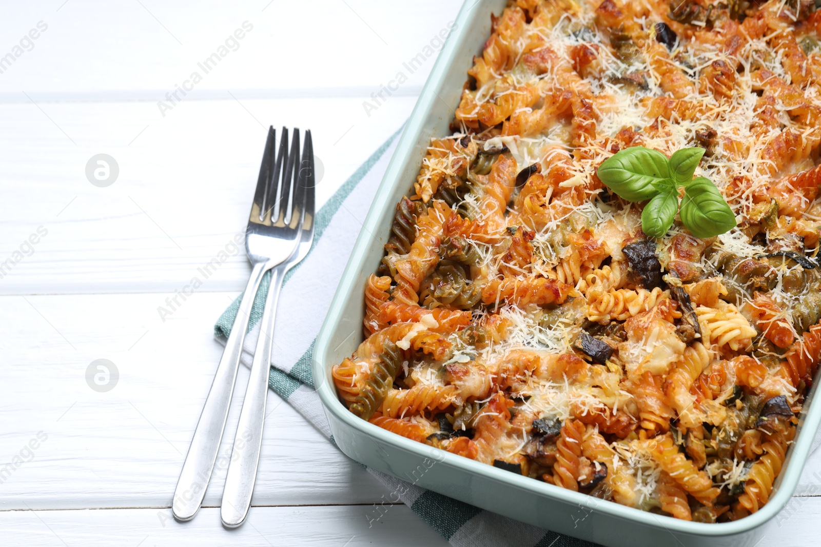 Photo of Delicious al forno pasta in baking dish on white wooden table, closeup