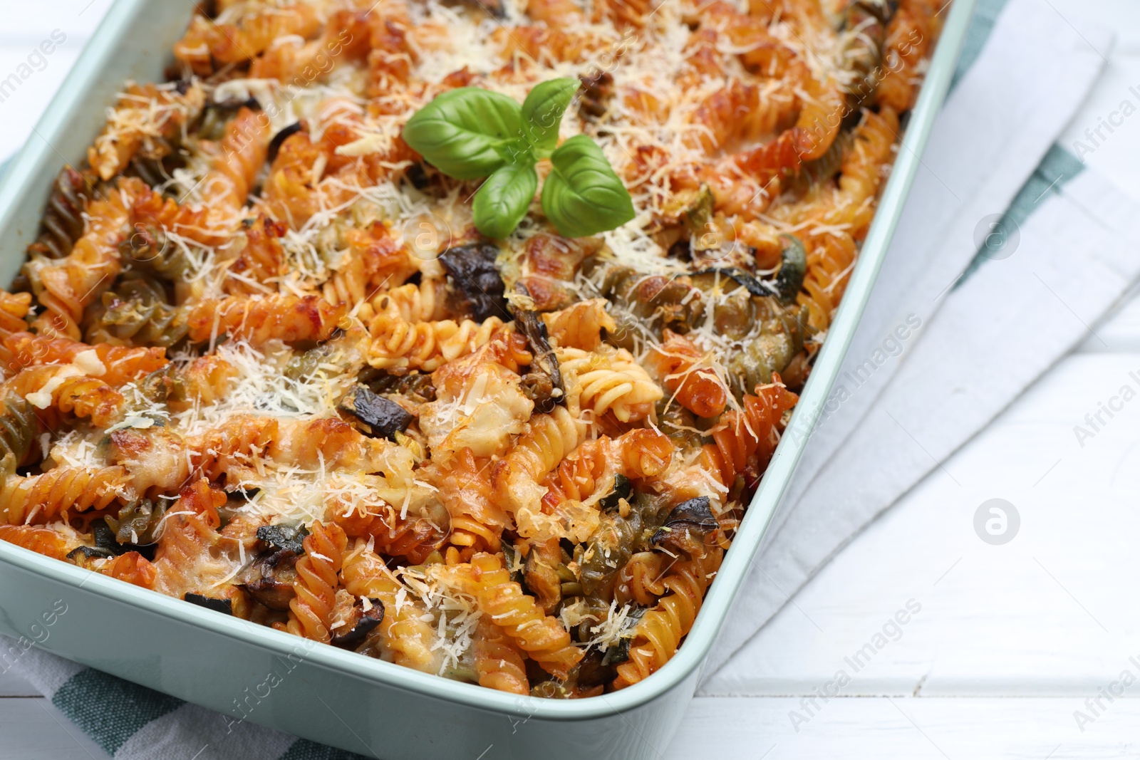 Photo of Delicious al forno pasta in baking dish on white wooden table, closeup