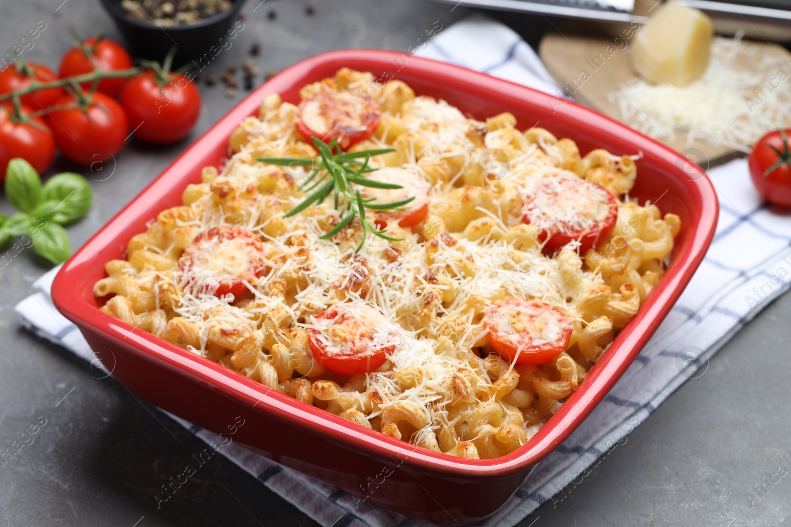 Photo of Delicious al forno pasta in baking dish on grey table, closeup