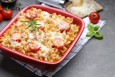 Photo of Delicious al forno pasta in baking dish on grey table, closeup