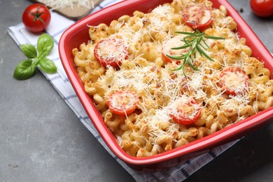 Photo of Delicious al forno pasta in baking dish on grey table, closeup