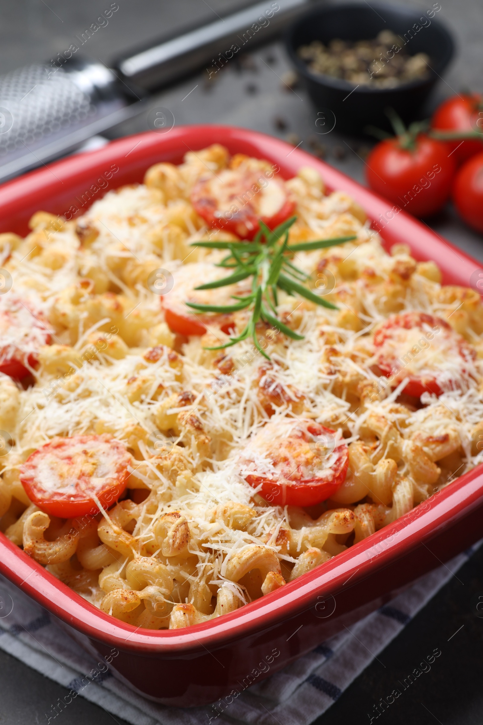 Photo of Delicious al forno pasta in baking dish on grey table, closeup