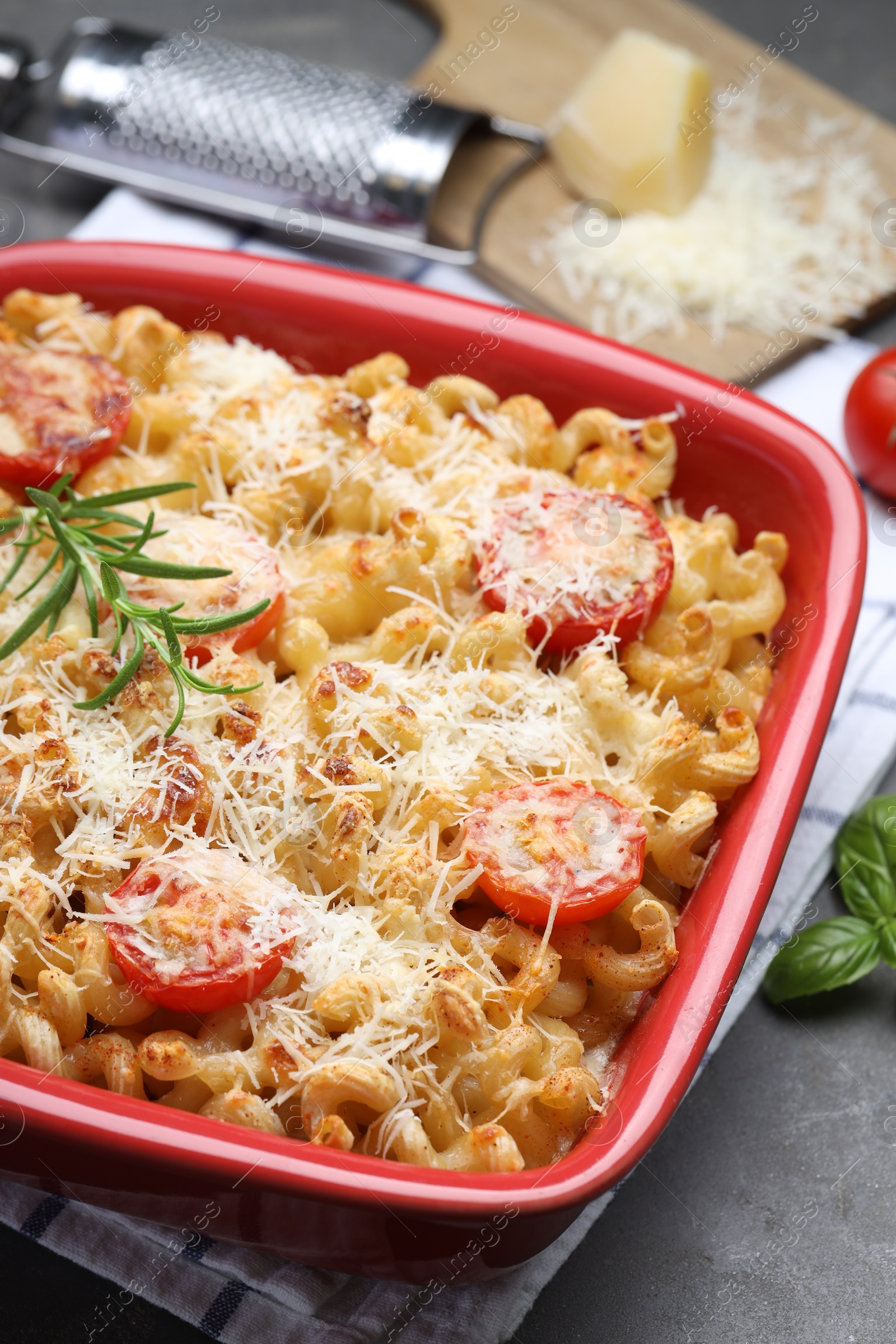 Photo of Delicious al forno pasta in baking dish on grey table, closeup