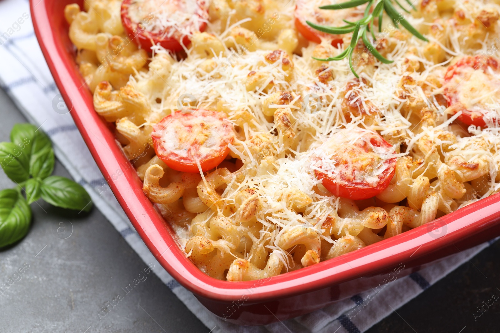 Photo of Delicious al forno pasta in baking dish on grey table, closeup