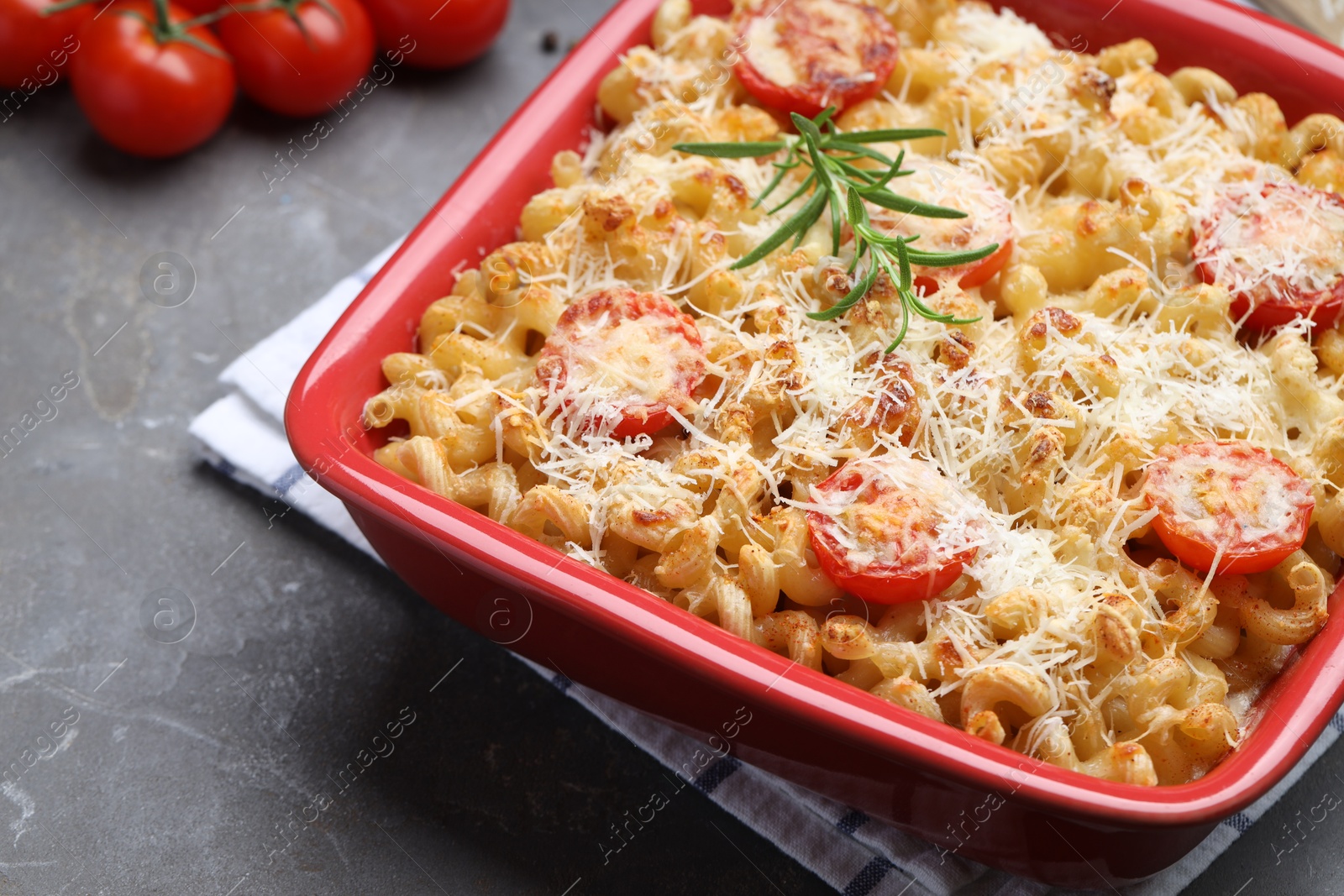 Photo of Delicious al forno pasta in baking dish on grey table, closeup