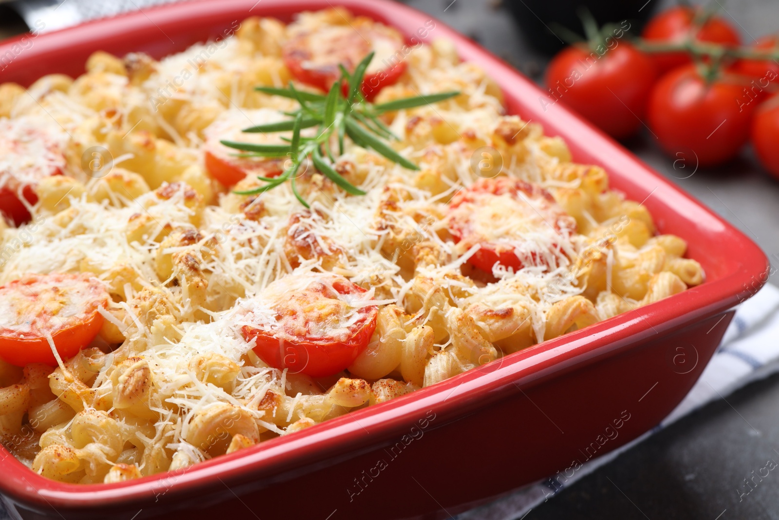 Photo of Delicious al forno pasta in baking dish on grey table, closeup