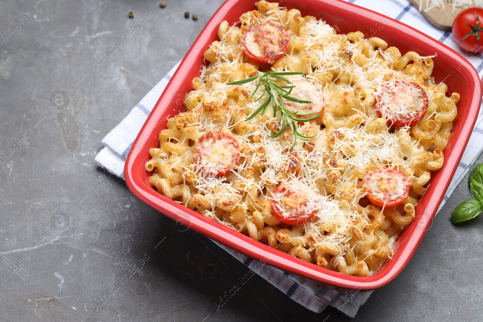 Photo of Delicious al forno pasta in baking dish on grey table, closeup